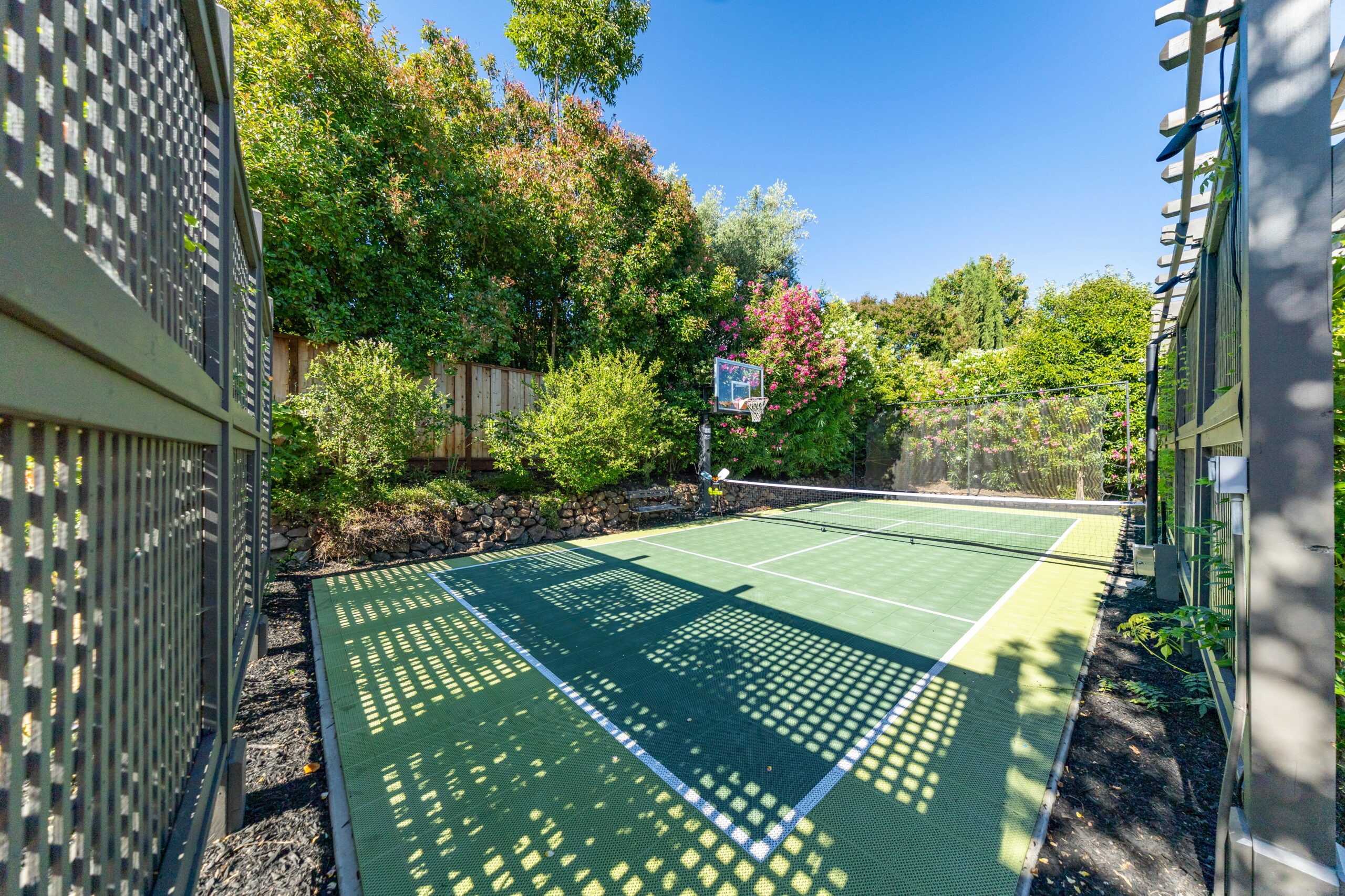 Combination basketball and pickleball court with hoop and dual-sport striping