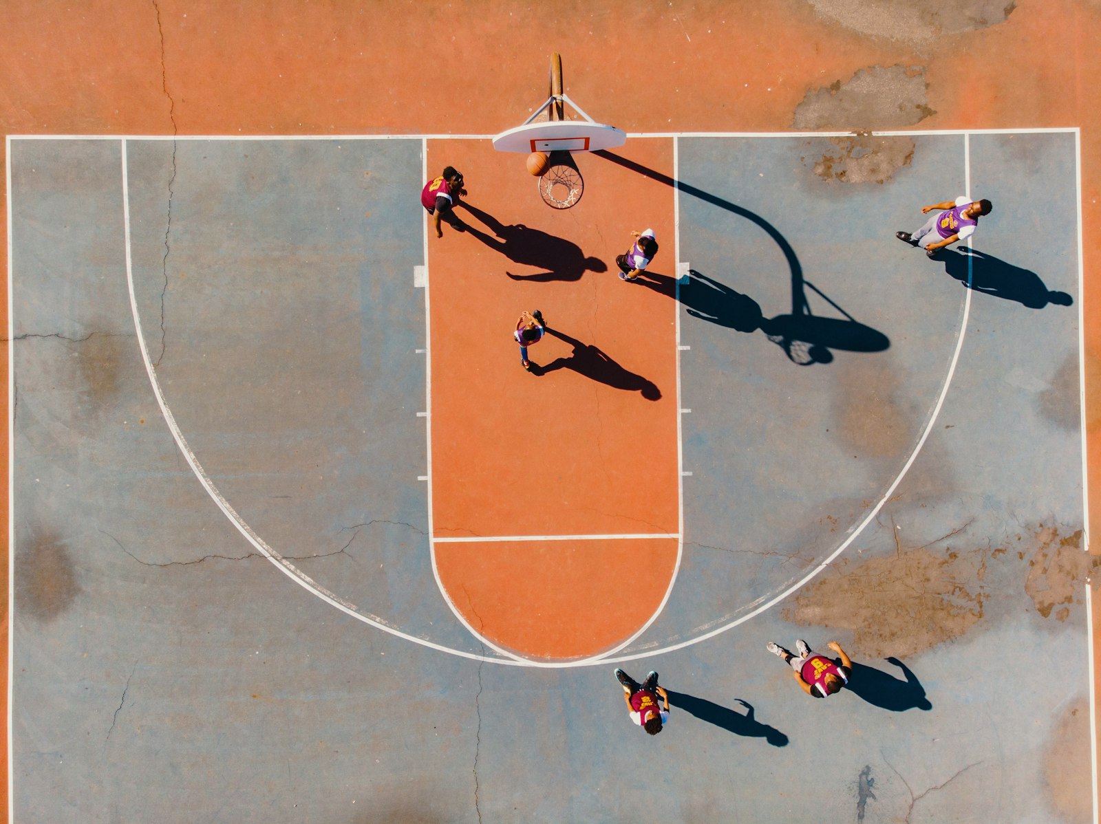 Aerial photo of players using a backyard court, illustrating kitchen and net placement for singles and doubles play