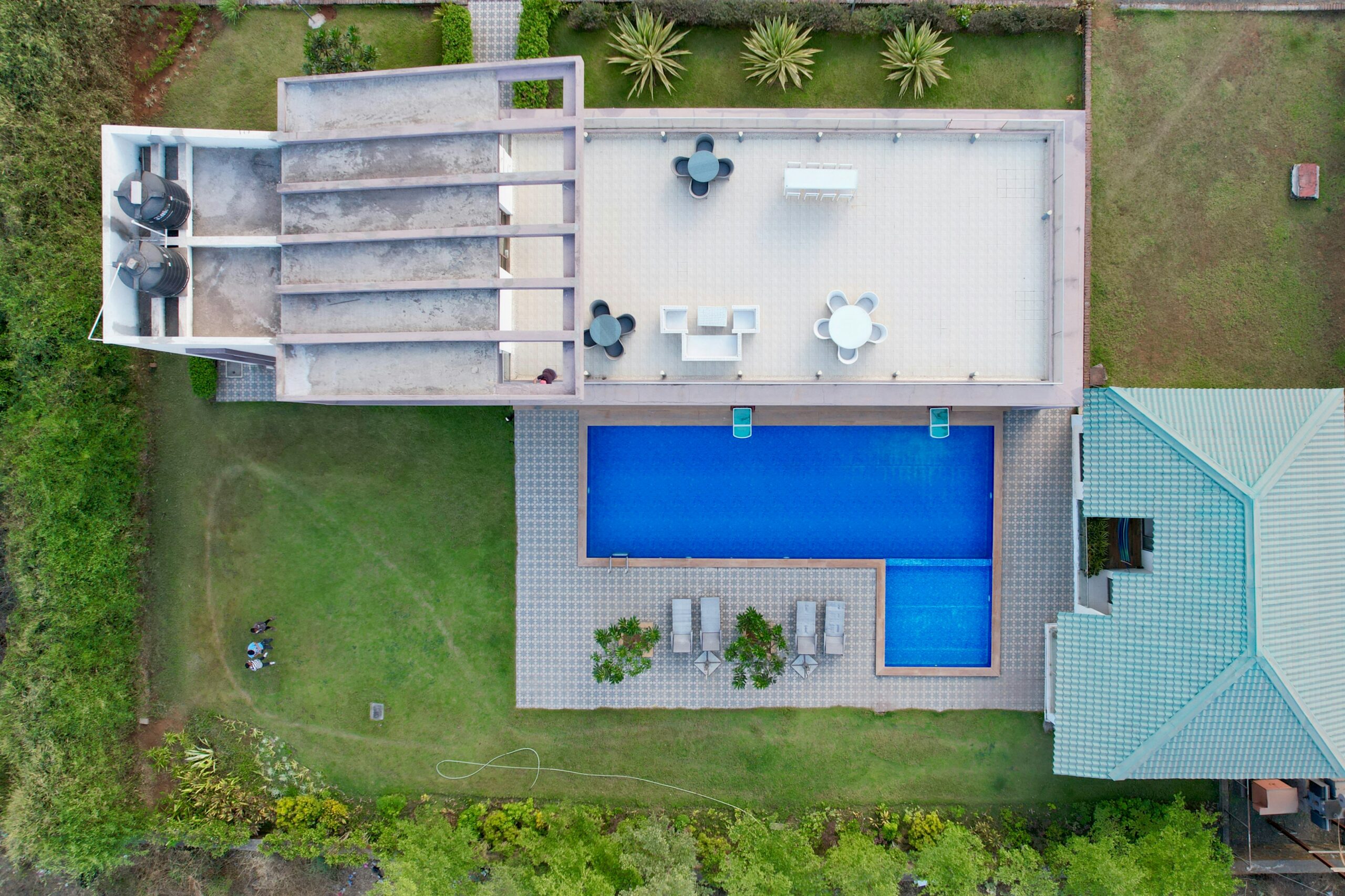 Backyard being planned for a private tennis court, showing available space and surrounding landscaping