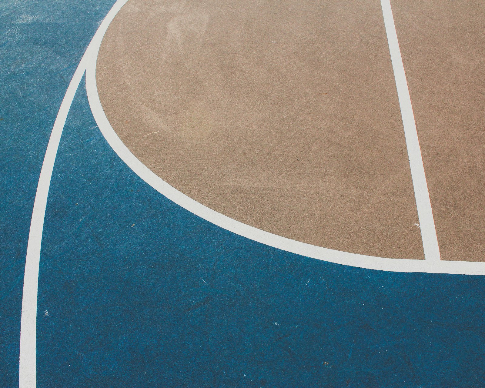 Blue and white painted sport court surface showing durable acrylic coating