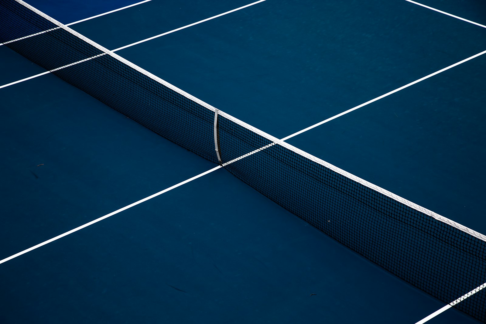 Close view of a blue court surface with a white boundary line illustrating clearance planning