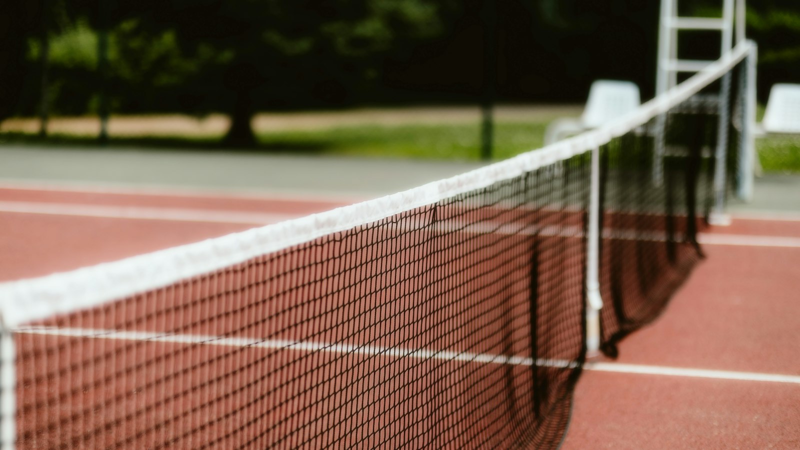 Sports court net strung between posts illustrating kitchen and service court measurement lines