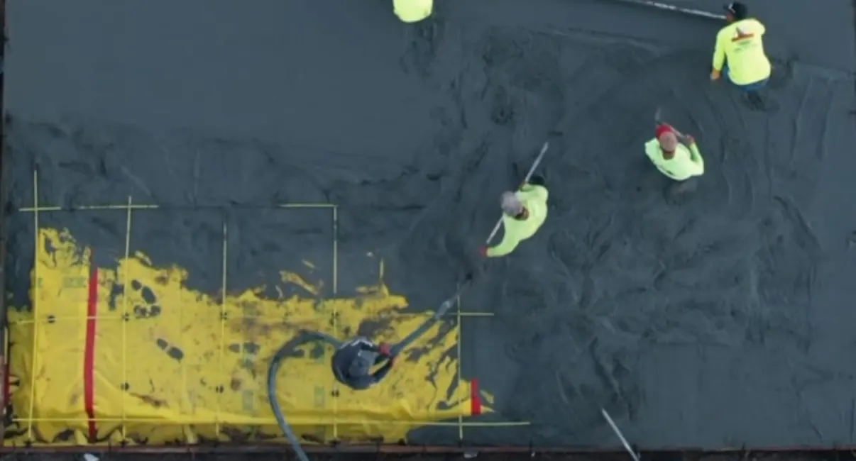 Crew pouring a concrete court slab